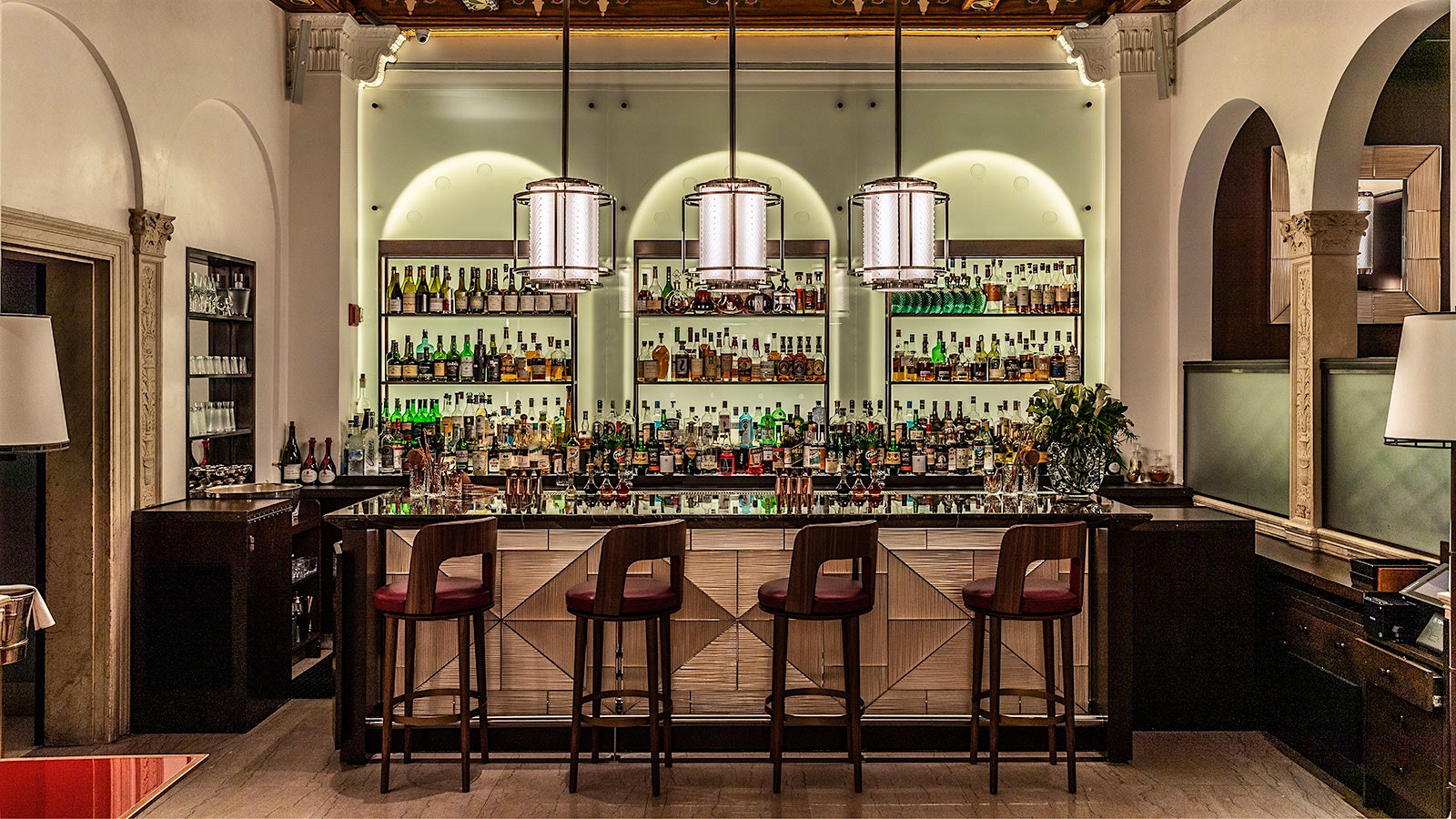 The Lalique bar at Daniel in New York, with contemporary-design leather chairs, a coffered ceiling and modern-design lamps hanging overhead